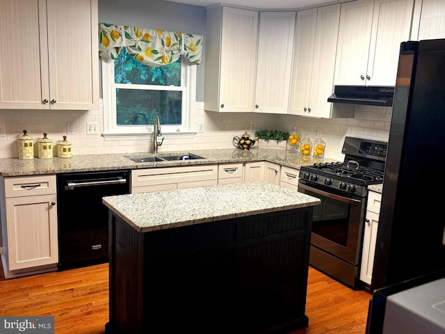 16068 Hayes Ln, Woodbridge, VA 22191 - kitchen with black appliances, under cabinet range hood, a sink, a kitchen island, and decorative backsplash