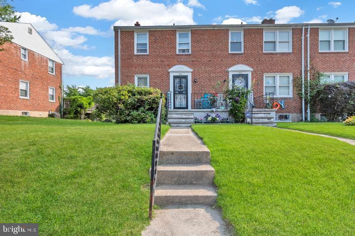 view of front of property featuring a front yard and brick siding