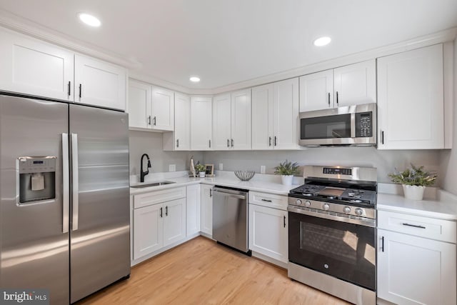 4914 22nd St N, Arlington, VA 22207 - kitchen with stainless steel appliances, a sink, light countertops, white cabinetry, and light wood-style floors