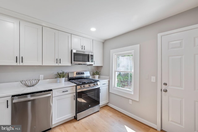 4914 22nd St N, Arlington, VA 22207 - kitchen featuring stainless steel appliances, light countertops, light wood finished floors, white cabinetry, and baseboards