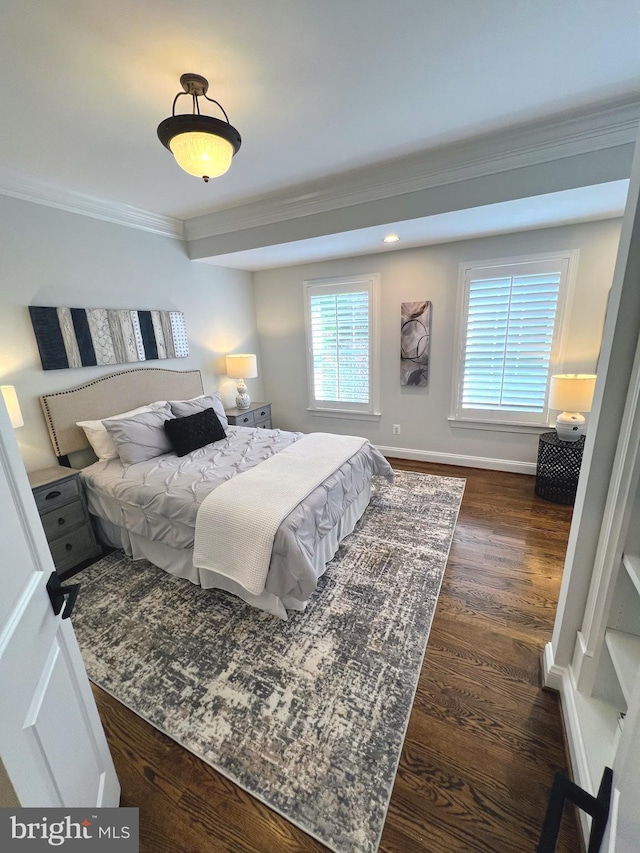 bedroom with crown molding, dark wood-type flooring, and baseboards