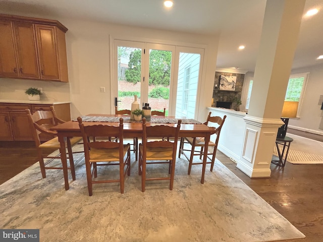 dining room with wood finished floors, plenty of natural light, recessed lighting, and a fireplace