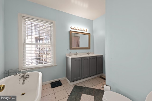 bathroom featuring toilet, plenty of natural light, a soaking tub, and tile patterned floors
