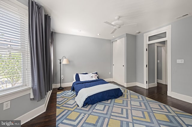 bedroom with hardwood / wood-style floors, baseboards, a closet, and ceiling fan
