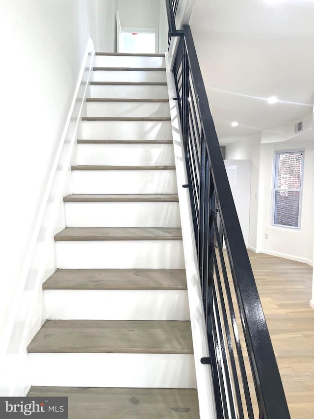 stairs featuring wood finished floors and baseboards
