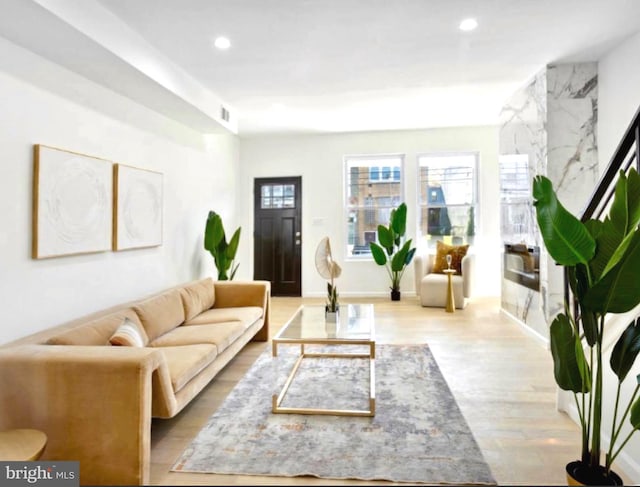 living room with wood finished floors, recessed lighting, and baseboards