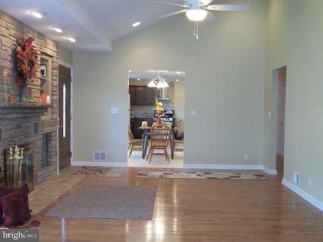 810 Hughes Dr, Hamilton, NJ 08690 - living room featuring a ceiling fan, high vaulted ceiling, wood finished floors, a fireplace, and baseboards