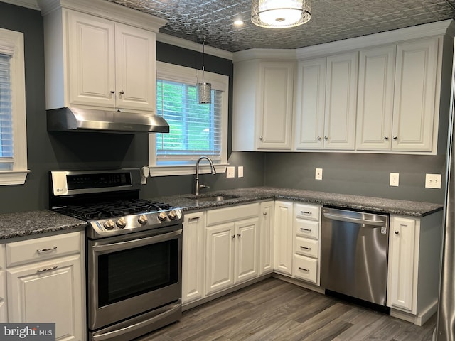kitchen featuring appliances with stainless steel finishes, under cabinet range hood, an ornate ceiling, a sink, and crown molding