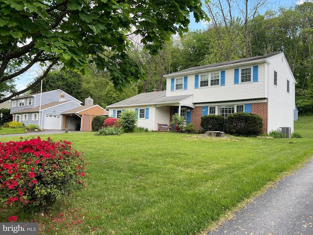 view of front facade with central AC, a front yard, and brick siding