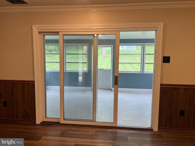 entryway featuring crown molding, a wainscoted wall, plenty of natural light, dark wood-style flooring, and wooden walls