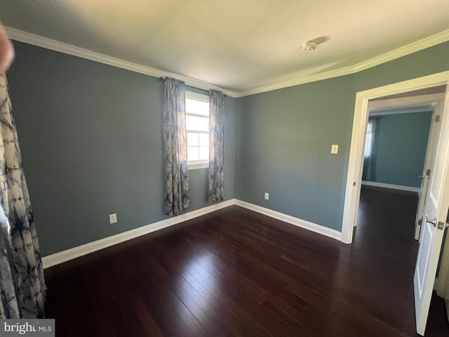 spare room with hardwood / wood-style floors, crown molding, and baseboards