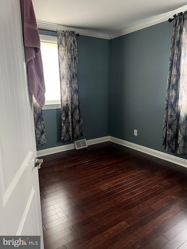 unfurnished room featuring hardwood / wood-style flooring, ornamental molding, and baseboards