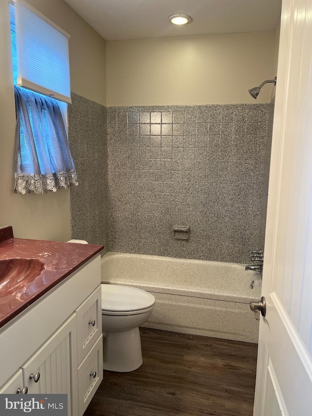 bathroom with vanity, toilet, tub / shower combination, recessed lighting, and wood finished floors
