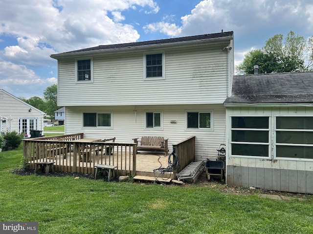 rear view of property with a lawn and a wooden deck