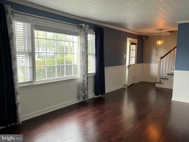 foyer featuring hardwood / wood-style flooring, a wainscoted wall, healthy amount of natural light, stairway, and crown molding
