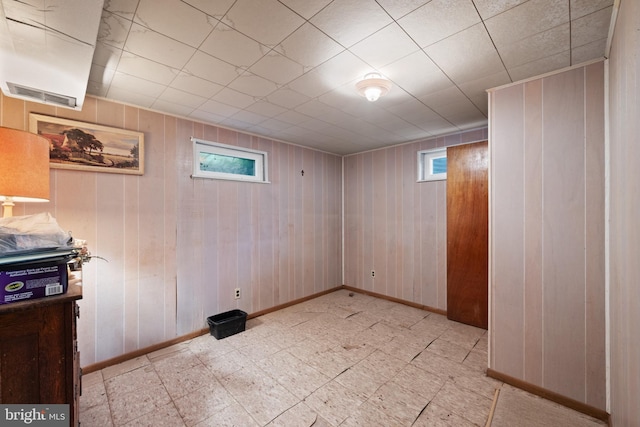 basement with baseboards and wooden walls