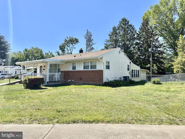 view of front of house with a porch, brick siding, a chimney, and central AC unit