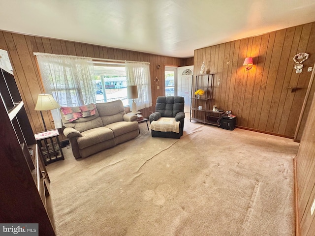 carpeted living area featuring wood walls