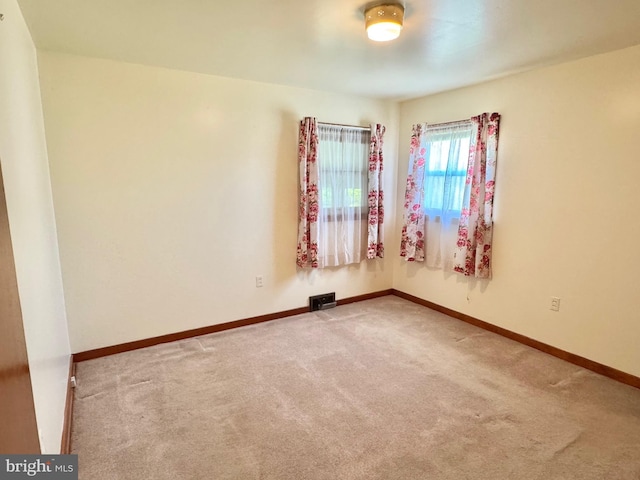 carpeted empty room featuring baseboards