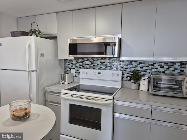 kitchen with white appliances, tasteful backsplash, light countertops, and gray cabinets