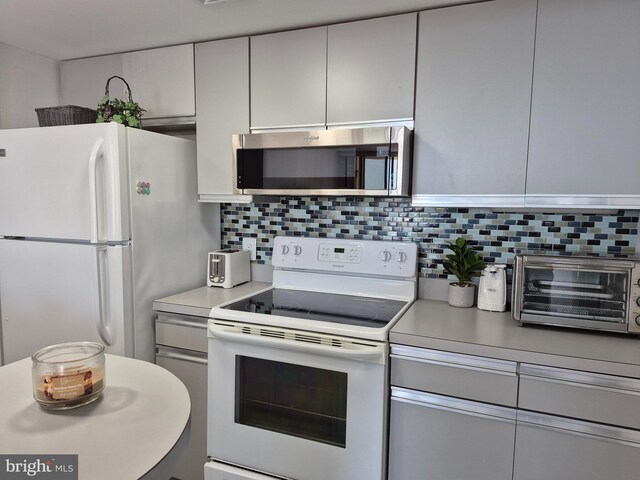 kitchen with white appliances, tasteful backsplash, light countertops, and gray cabinets