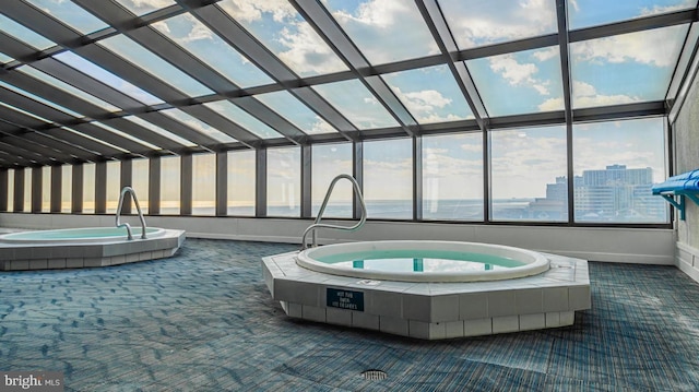 view of swimming pool with a hot tub