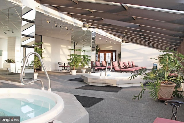 view of swimming pool with a ceiling fan, french doors, and a patio