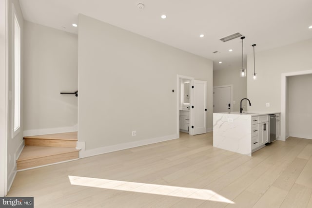 kitchen with dishwasher, a sink, light wood-style flooring, recessed lighting, and baseboards