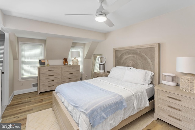 bedroom featuring light wood-style floors, a ceiling fan, and baseboards