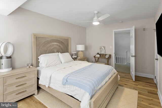 bedroom with light wood-style flooring, baseboards, and a ceiling fan