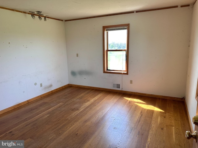 empty room featuring wood finished floors and baseboards