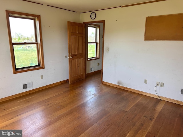 spare room with wood finished floors and baseboards