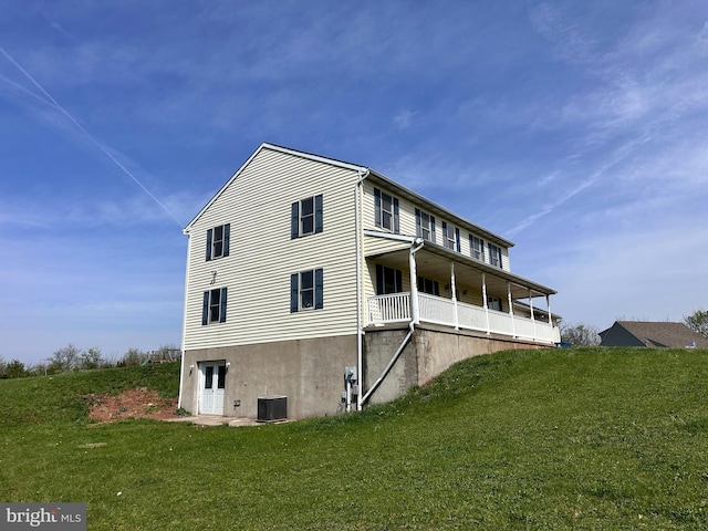 back of property featuring a lawn and cooling unit
