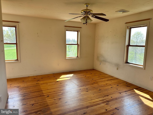 spare room featuring plenty of natural light, hardwood / wood-style flooring, and ceiling fan