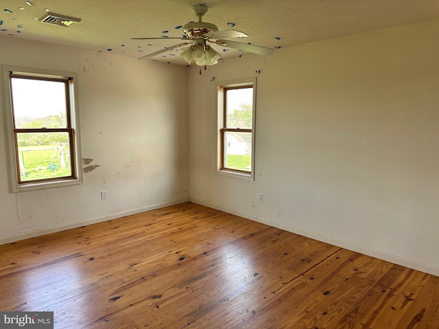 empty room featuring light wood-style flooring, baseboards, and a ceiling fan