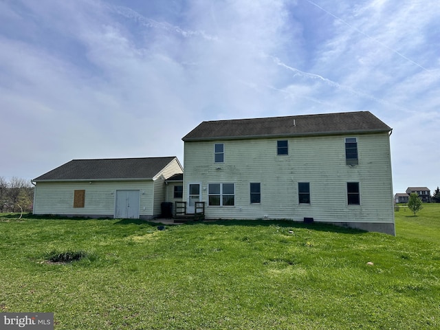 rear view of house featuring a yard
