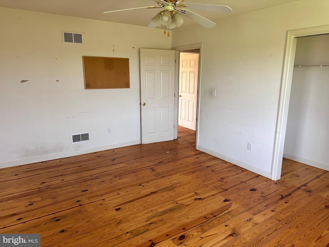 unfurnished bedroom with wood finished floors, baseboards, a closet, and ceiling fan