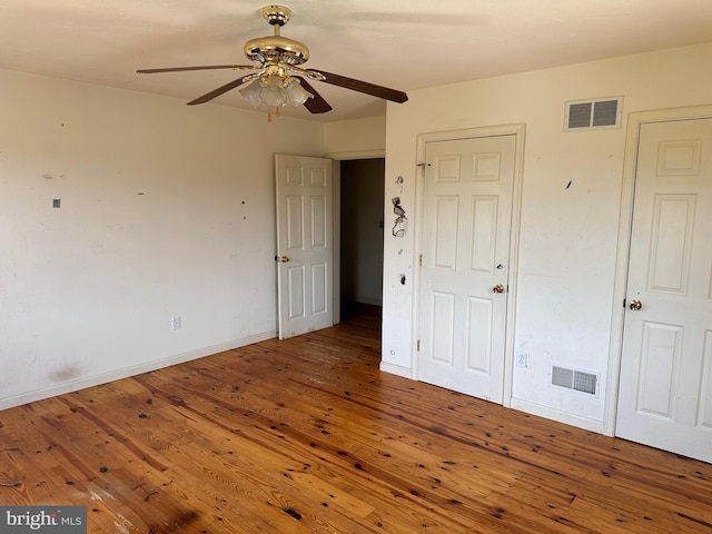 unfurnished bedroom with hardwood / wood-style flooring, baseboards, and a ceiling fan