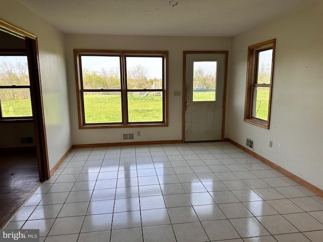 unfurnished room featuring baseboards and light tile patterned floors