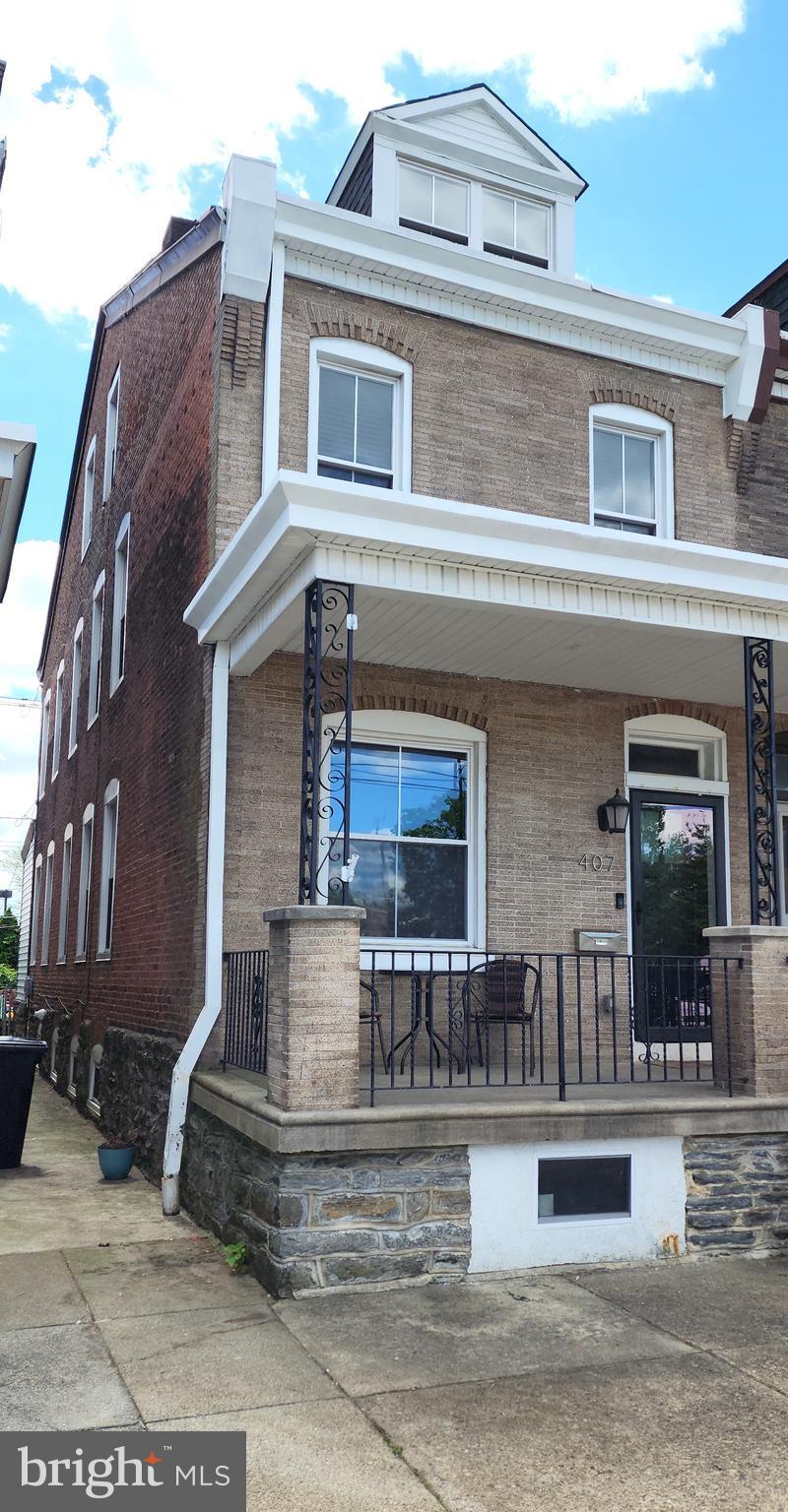 townhome / multi-family property with covered porch and brick siding