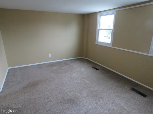 carpeted empty room featuring baseboards