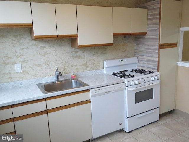 kitchen featuring white appliances, a sink, tasteful backsplash, and light tile patterned floors
