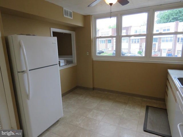 kitchen featuring freestanding refrigerator, healthy amount of natural light, a ceiling fan, and baseboards