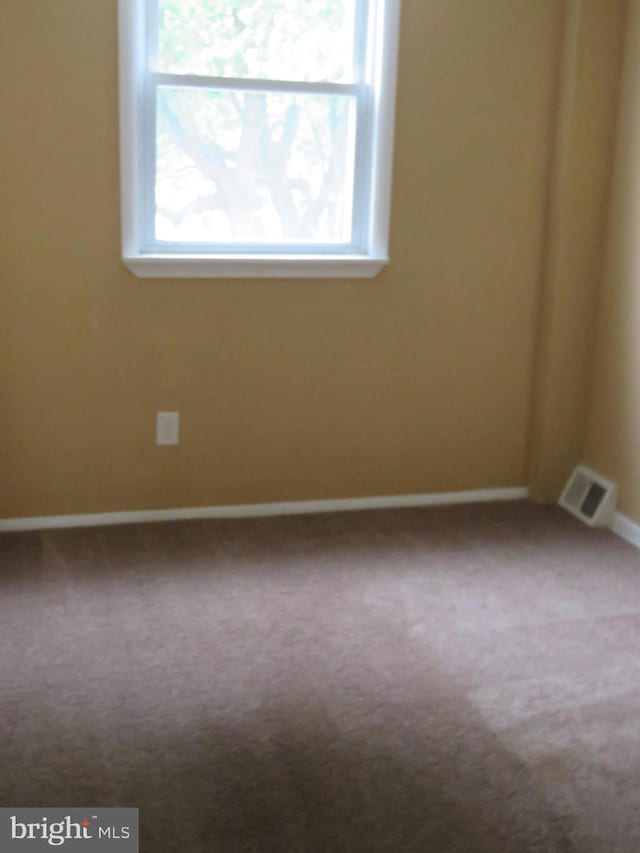 carpeted spare room with baseboards