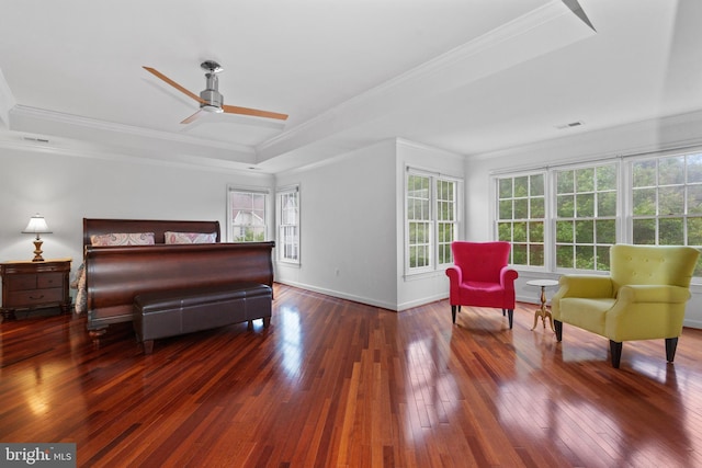 bedroom with a raised ceiling, hardwood / wood-style floors, baseboards, and crown molding