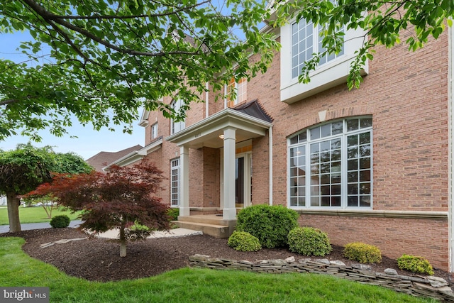 entrance to property featuring brick siding