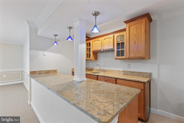 kitchen featuring crown molding, a peninsula, brown cabinets, light carpet, and glass insert cabinets