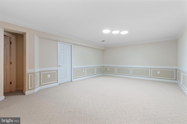 basement with crown molding, carpet floors, a decorative wall, and a wainscoted wall