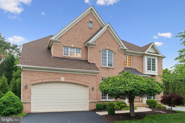 traditional home with brick siding, driveway, and roof with shingles