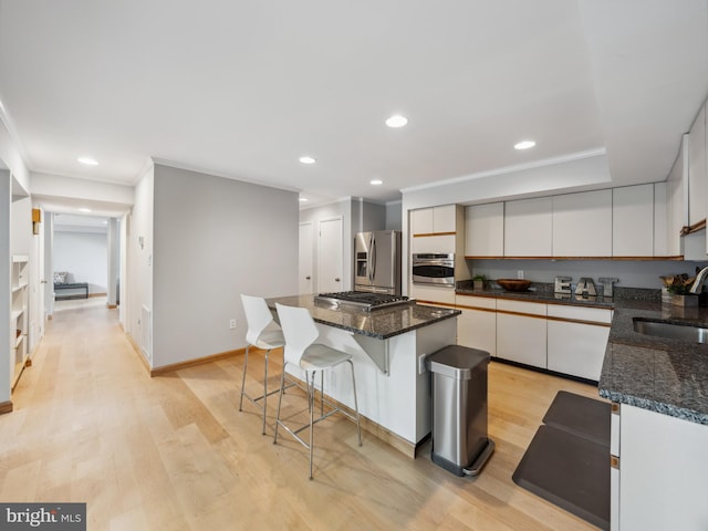 11041 Solaridge Dr, Reston, VA 20191 - kitchen with appliances with stainless steel finishes, a breakfast bar, crown molding, light wood-style floors, and a sink